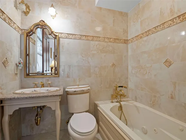 a bathroom with a sink a toilet a mirror and shower