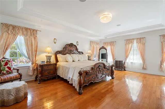 a spacious bedroom with a bed and wooden floor