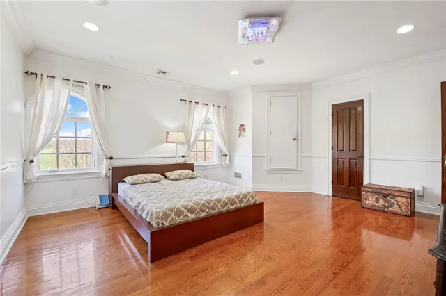 a spacious bedroom with a bed and a dresser next to a window