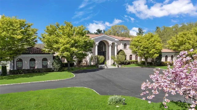 a front view of a house with a garden and trees
