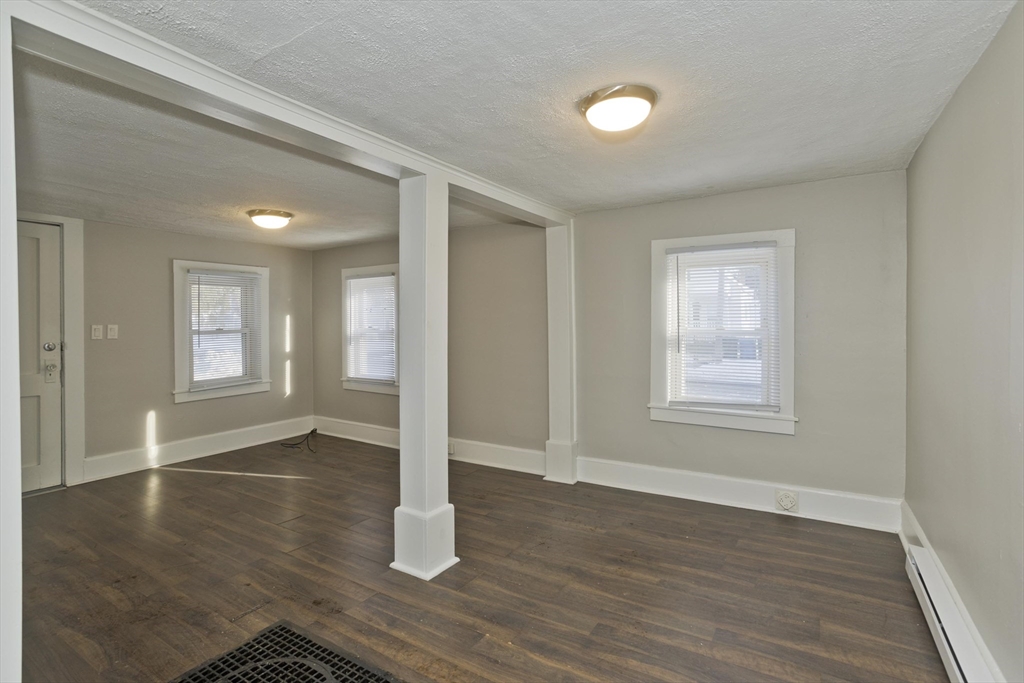 98 Ellsworth Avenue Springfield, MA 01118 - Photo 4 of 17 an empty room with wooden floor and windows