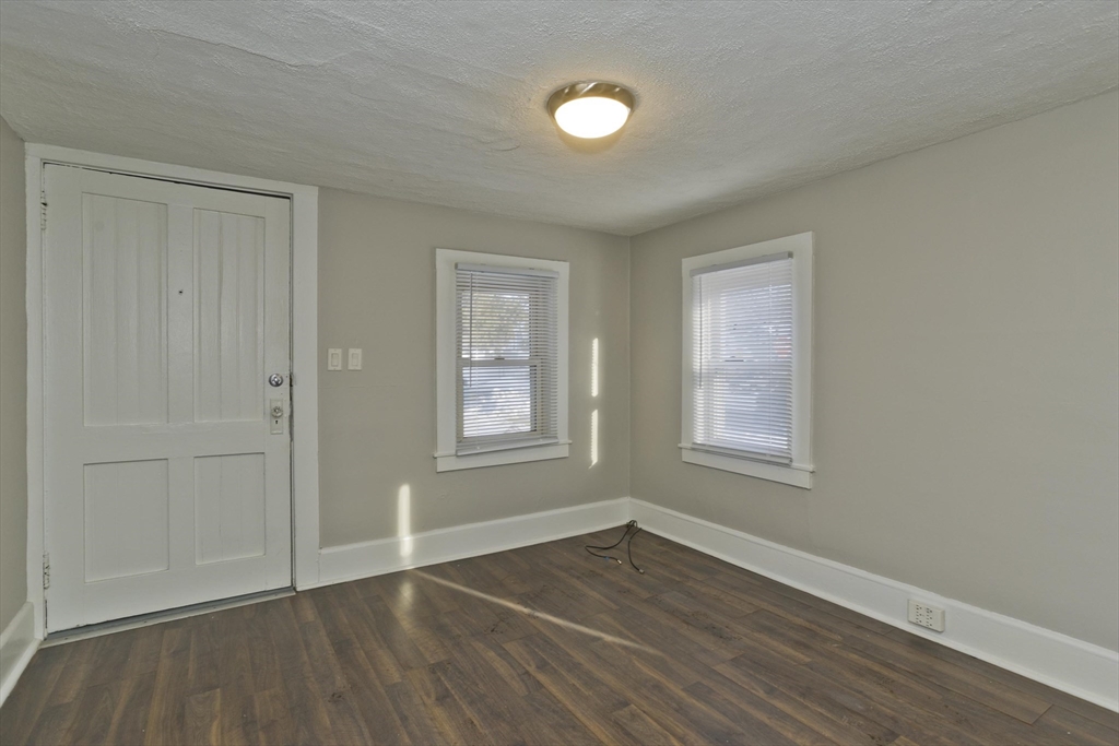 98 Ellsworth Avenue Springfield, MA 01118 - Photo 5 of 17 an empty room with wooden floor and windows