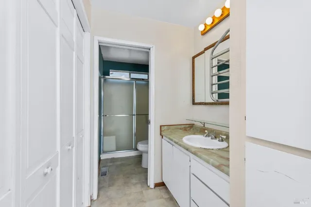 a bathroom with a granite countertop sink and a mirror