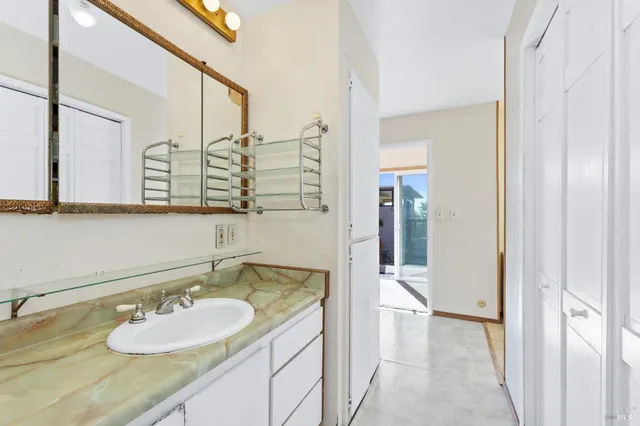 a bathroom with a granite countertop sink and a mirror