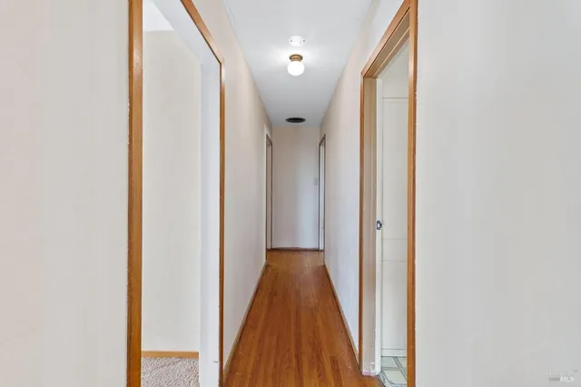 a view of a hallway with wooden floor and entryway