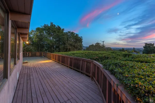 a view of balcony with wooden floor and fence