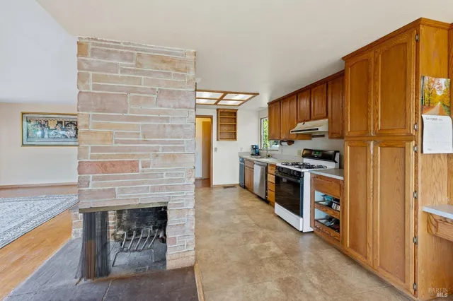 a kitchen with stainless steel appliances granite countertop a refrigerator a stove and a sink