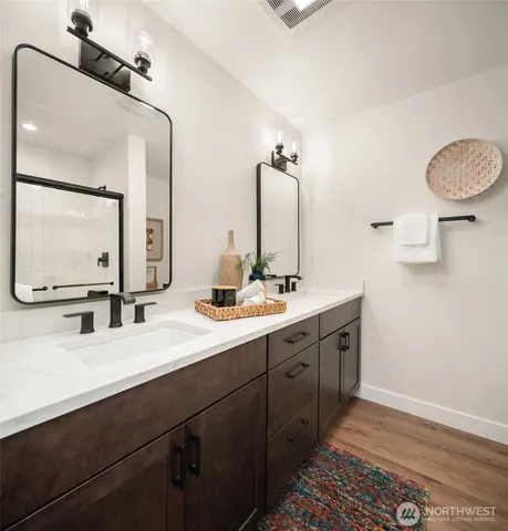 a bathroom with a double vanity sink and a mirror