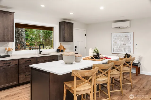 a kitchen with a dining table chairs and sink