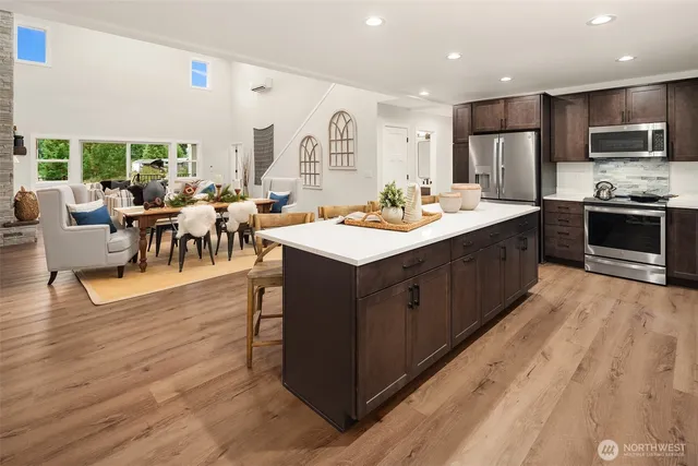 a large kitchen with kitchen island a sink table and chairs