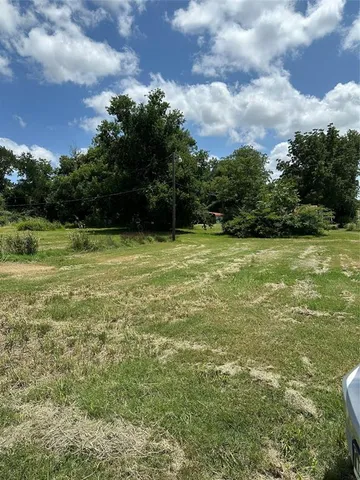 a view of a field with an trees in the background
