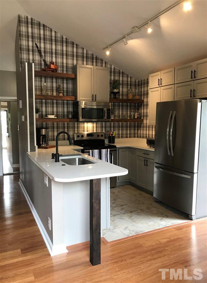 3306 Mill Run, Unit 3306 Raleigh, NC 27612 - Photo 1 of 24 a kitchen with stainless steel appliances granite countertop a sink stove and refrigerator