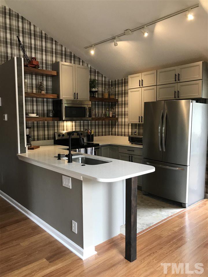 3306 Mill Run, Unit 3306 Raleigh, NC 27612 - Photo 2 of 24 a kitchen with stainless steel appliances a sink and a refrigerator