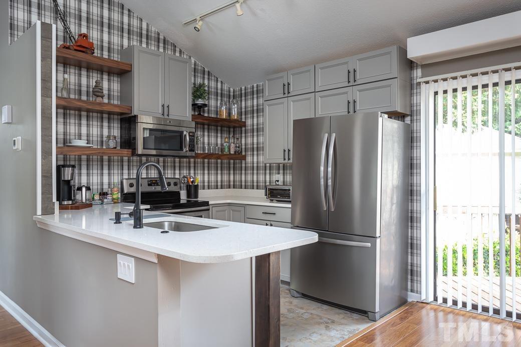 3306 Mill Run, Unit 3306 Raleigh, NC 27612 - Photo 14 of 24 a kitchen with stainless steel appliances a sink and a refrigerator