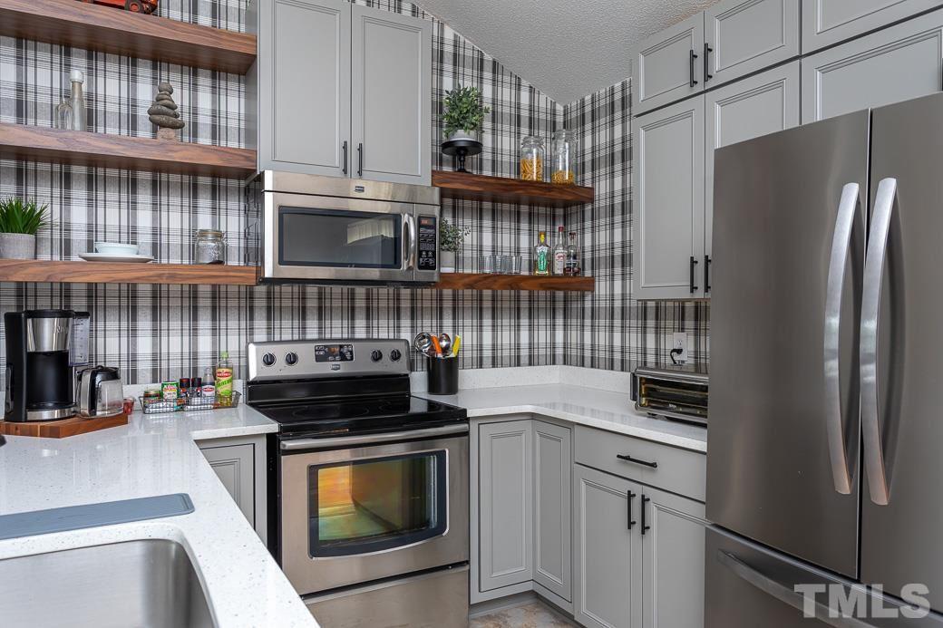 3306 Mill Run, Unit 3306 Raleigh, NC 27612 - Photo 15 of 24 a kitchen with stainless steel appliances a stove a sink and a refrigerator