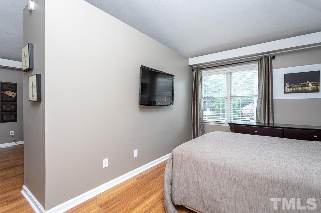 3306 Mill Run, Unit 3306 Raleigh, NC 27612 - Photo 19 of 24 a bedroom with a bed and a flat screen tv