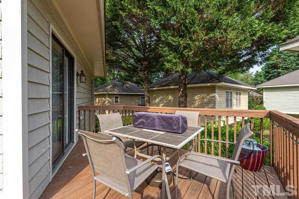3306 Mill Run, Unit 3306 Raleigh, NC 27612 - Photo 8 of 24 a view of a patio with table and chairs with wooden floor and fence