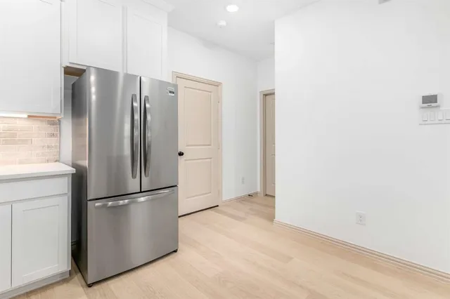 a metallic refrigerator freezer sitting in a kitchen