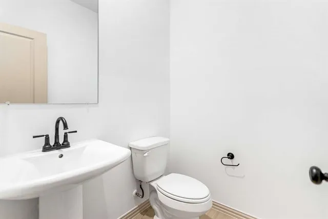 a bathroom with a toilet a sink and mirror