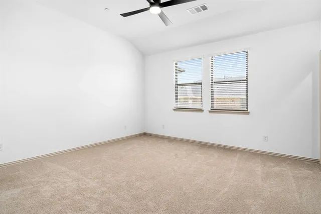 an empty room with windows and fan