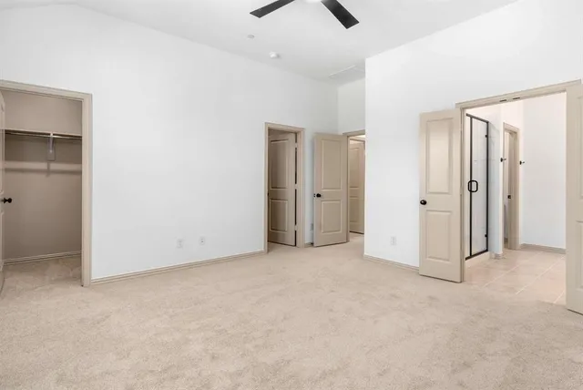 an empty room with closet and a ceiling fan