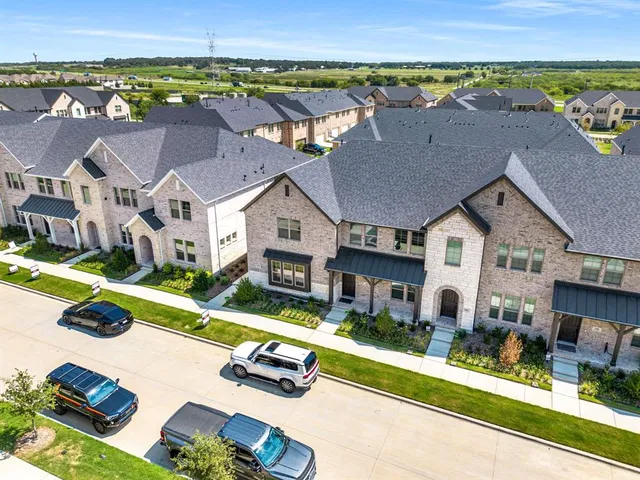 an aerial view of multiple houses with a yard