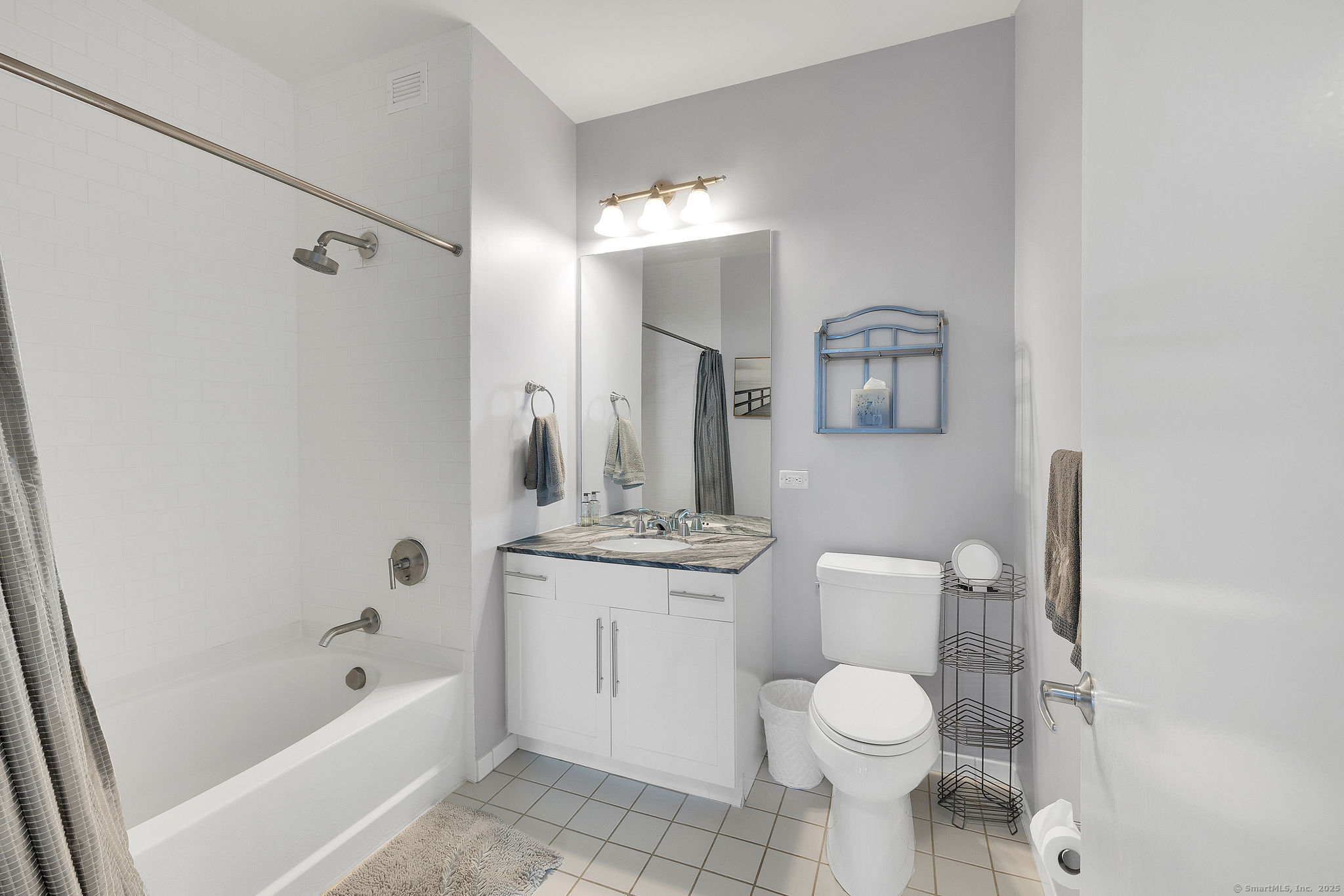 1515 Summer Street, Unit 302 Stamford, CT 06905 - Photo 22 of 33 a bathroom with a toilet sink vanity tub and mirror