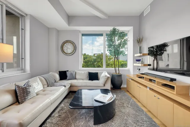 a living room with furniture dining table and a floor to ceiling window
