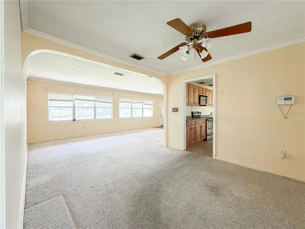 a view of a livingroom with a ceiling fan and window