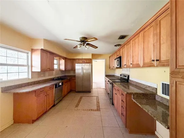 a large kitchen with stainless steel appliances granite countertop a stove and a sink