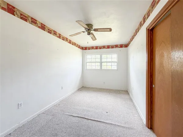 a view of a livingroom with a window and a ceiling fan