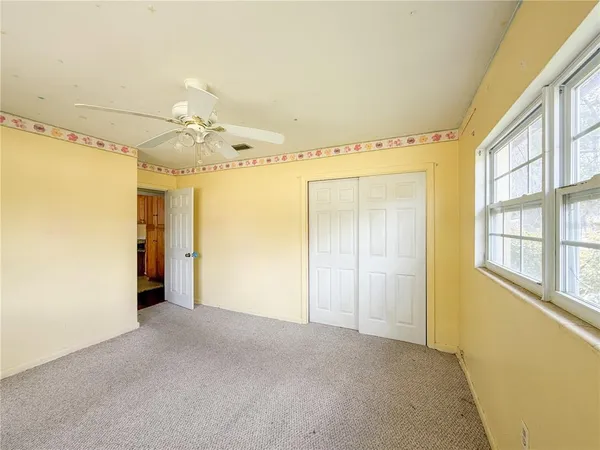 a view of a big room with wooden floor and windows