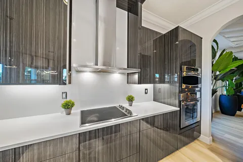 a kitchen with a dining table chairs and white cabinets