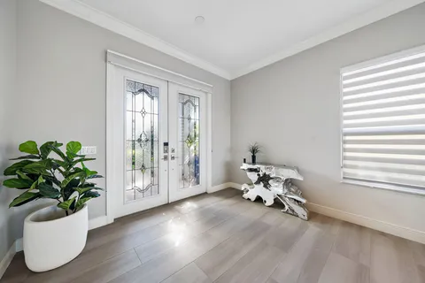 a living room with furniture a chandelier and a large window