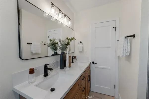a bedroom with a bed and a potted plant on the dresser