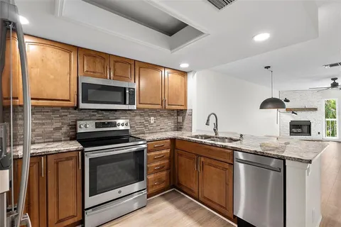 a kitchen with stainless steel appliances granite countertop a refrigerator and a stove top oven