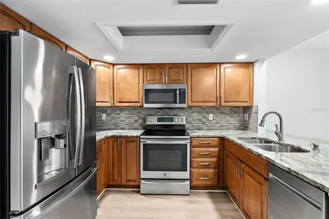 a kitchen with stainless steel appliances granite countertop a refrigerator stove and microwave