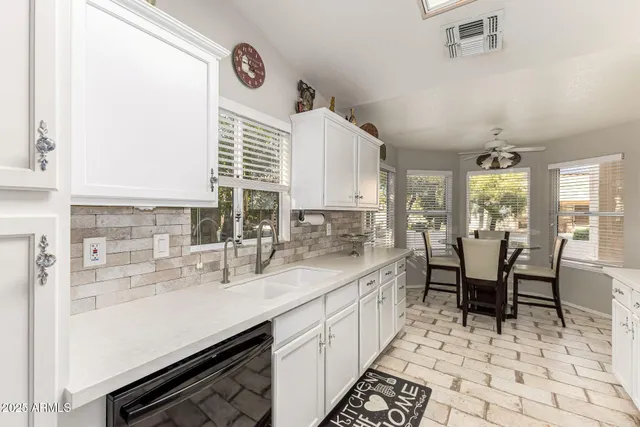 a kitchen with white cabinets and appliances