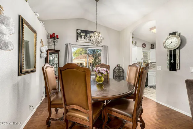 a view of a dining room with furniture a chandelier and wooden floor