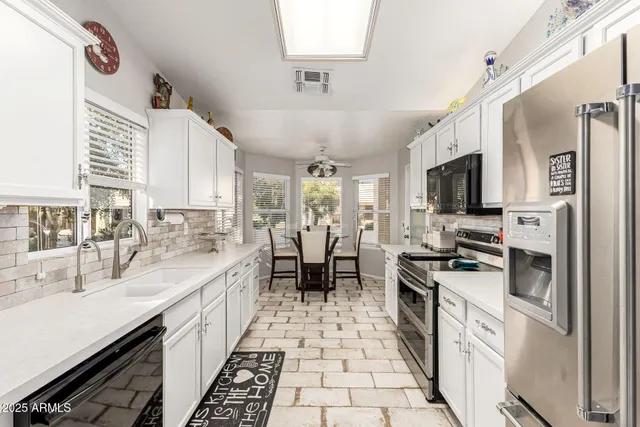 a large white kitchen with a stove a sink and a refrigerator