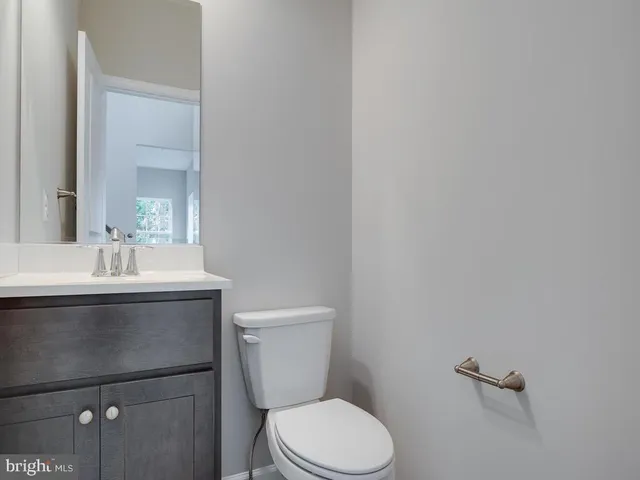 a bathroom with a toilet a sink and mirror
