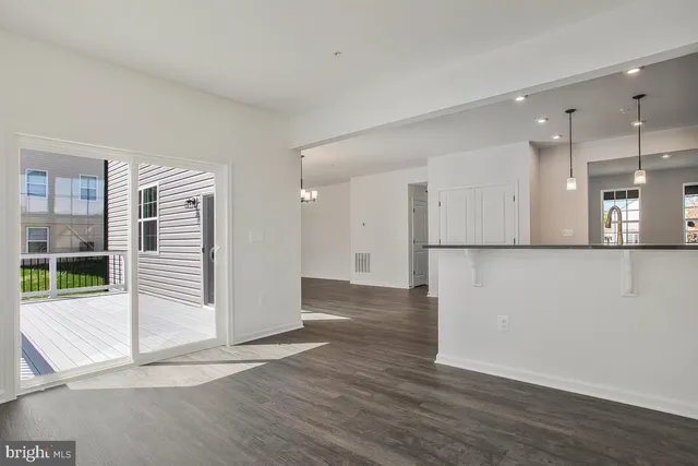 a view of a big room with wooden floor and windows