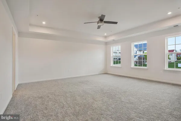 an empty room with windows and ceiling fan