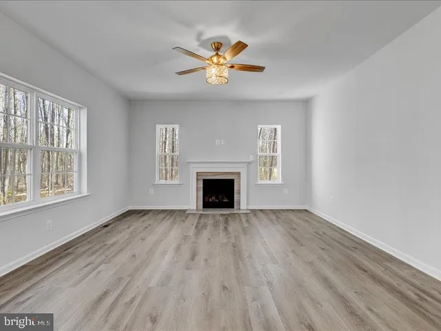 a view of an empty room with a window and fireplace