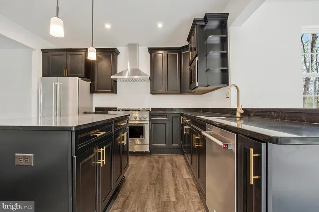 a kitchen with stainless steel appliances granite countertop a sink a stove and a refrigerator