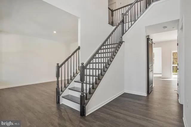 a view of staircase with wooden floor and white walls