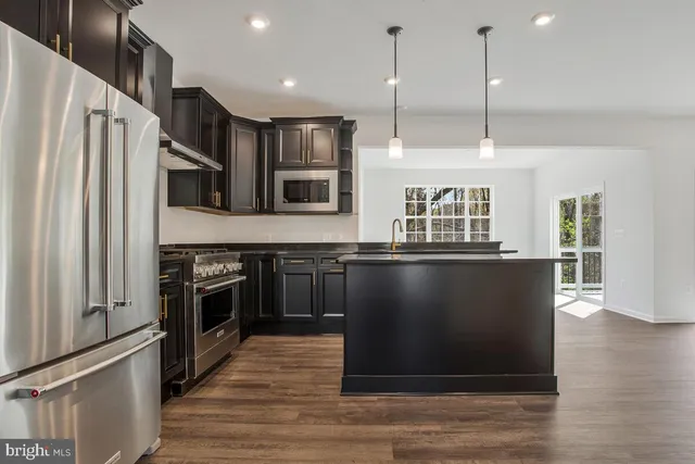 a kitchen with stainless steel appliances granite countertop a sink a stove and a refrigerator