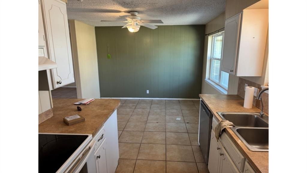 4004 Vicky Street Big Spring, TX 79720 - Photo 13 of 37 Kitchen with white electric range oven, white cabinets, a ceiling fan, light countertops, and a textured ceiling