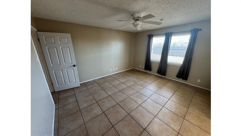 4004 Vicky Street Big Spring, TX 79720 - Photo 14 of 37 Tiled empty room featuring a textured ceiling and ceiling fan