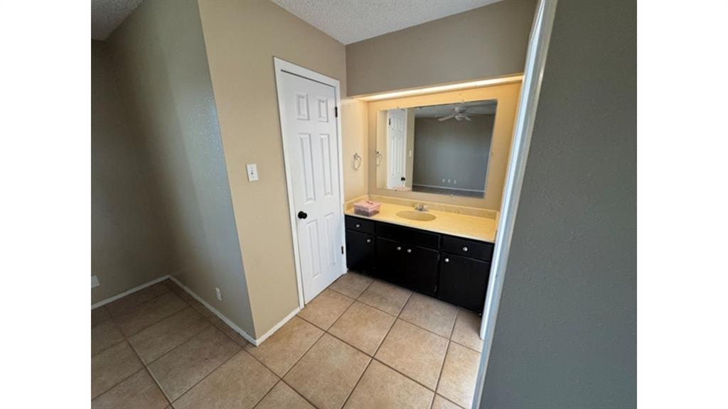 4004 Vicky Street Big Spring, TX 79720 - Photo 15 of 37 Bathroom with vanity, light tile patterned floors, and a textured ceiling
